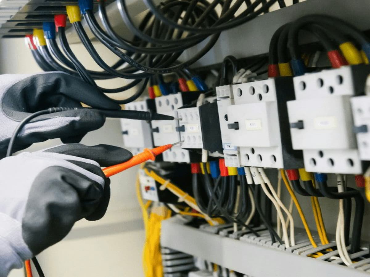 Electrician testing electrical panel circuits